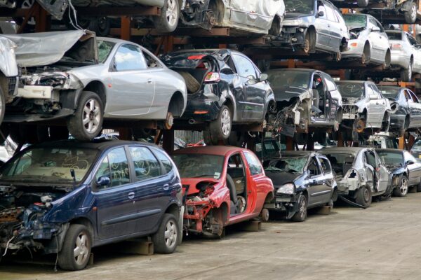 車のショールームで商談が成立し、握手を交わす男女の様子。背景には車両が映っている。