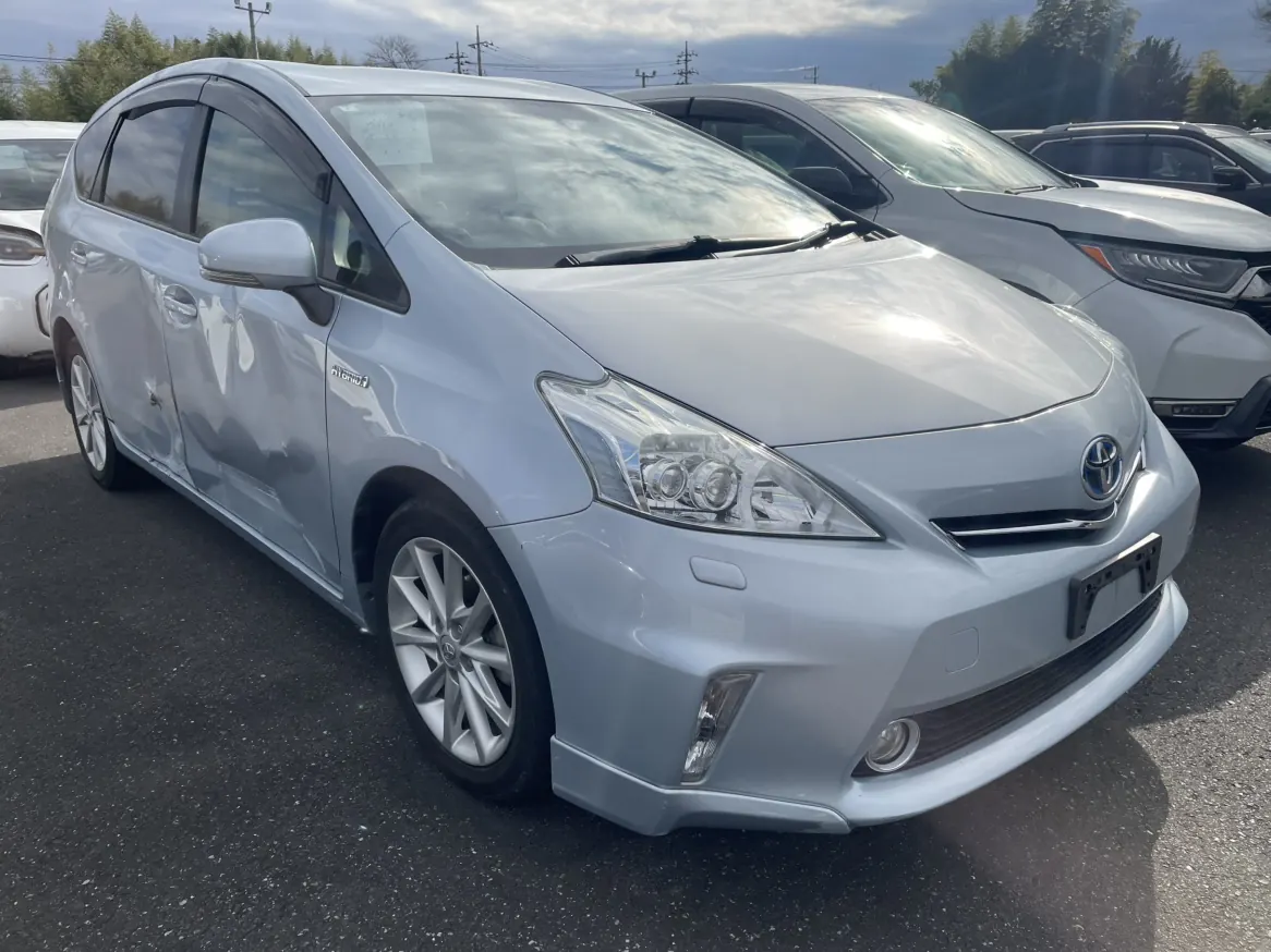 Silver Toyota Prius Alpha hybrid front side view with side body dents