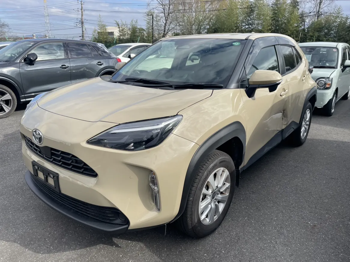 Beige Toyota Yaris Cross front side view with light side damage