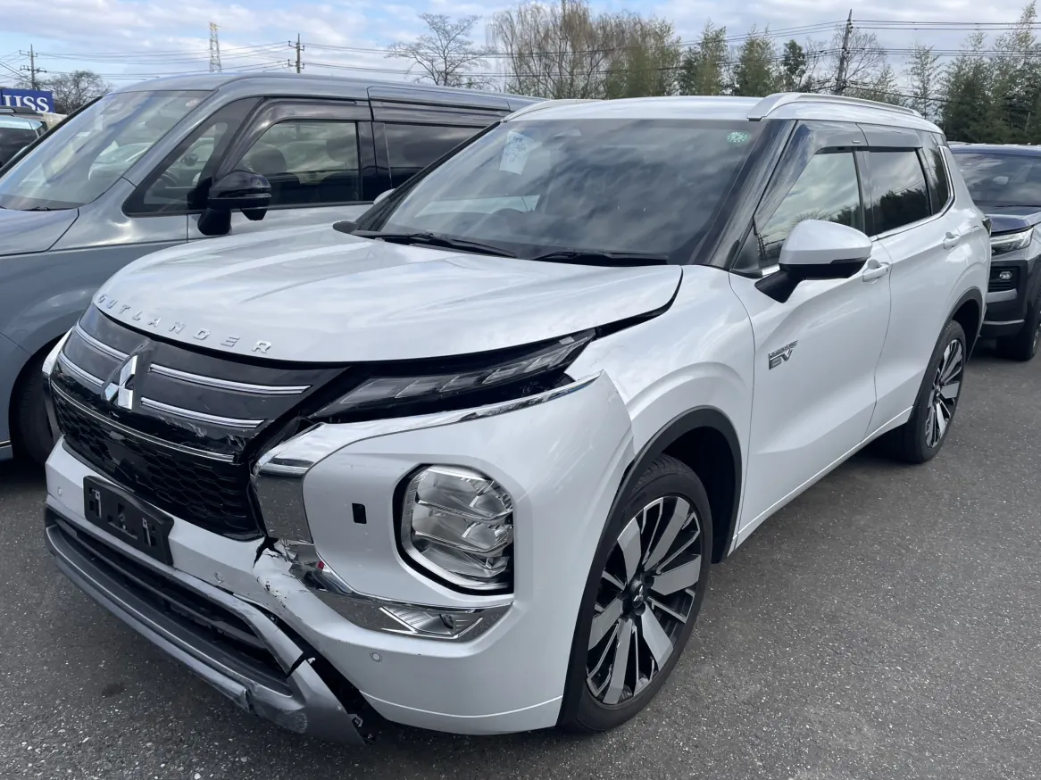 White Mitsubishi Outlander PHEV damaged front side view with front bumper damage